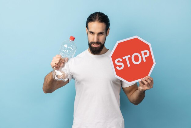 Mann, der Plastikflasche hält und rotes Schild stoppt, das sich Sorgen um die Umwelt macht