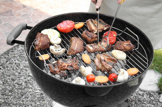 Mann, der Rippen auf Grillgrill kocht