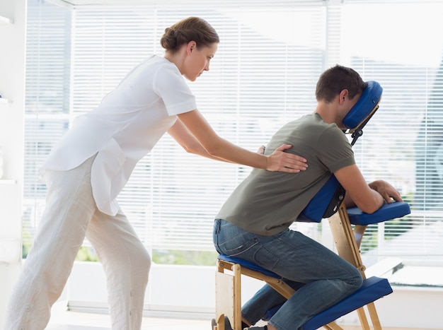 Mann, der Rückenmassage vom Physiotherapeuten empfängt