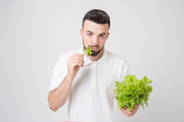 Mann, der Salate nah oben hält. Konzept. Superfoods