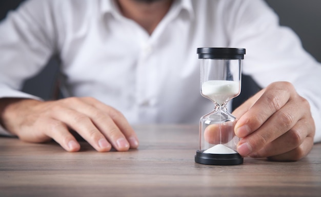 Mann, der Sanduhr hält. Terminkonzept