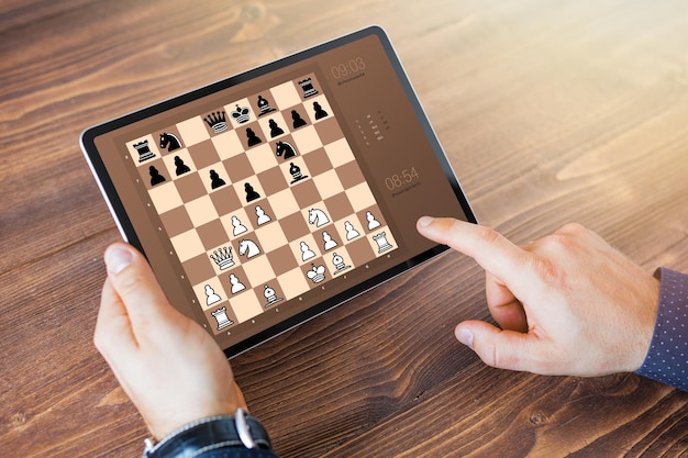 Mann, der schach online auf tablet-computer spielt Premium-Foto