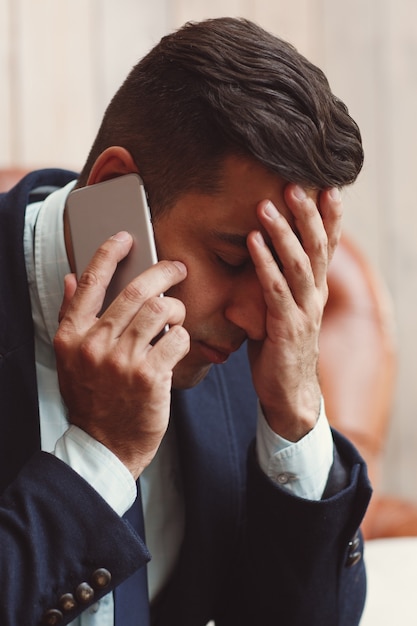 Mann, der schlechte Nachrichten am Telefon erhält.