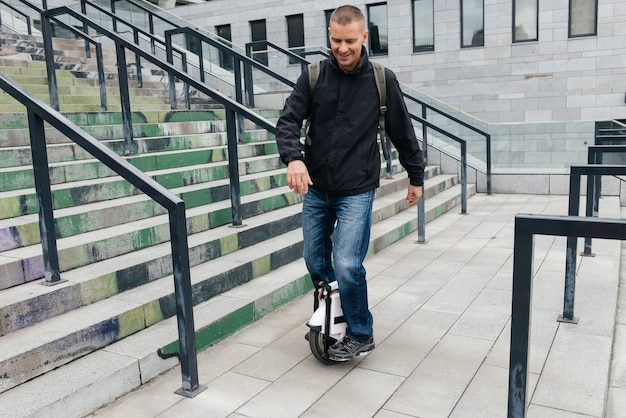 Mann, der schnell auf elektrischem Einrad auf Stadtstraße reitet.