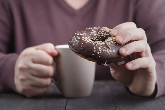 Mann, der Schokoladendonut isst