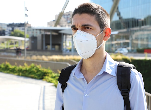 Mann, der Schutzmaske in der modernen Stadtstraße trägt