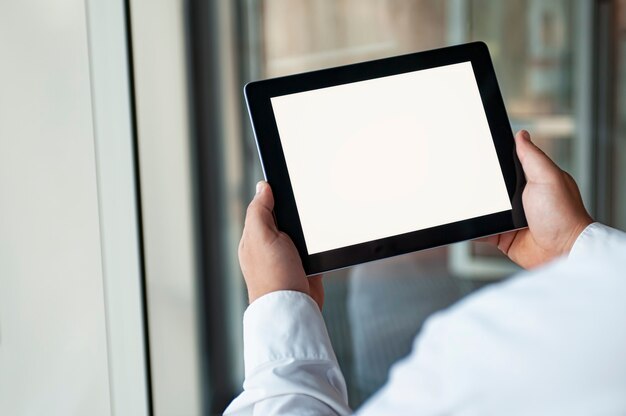 Foto mann, der schwarze tablette in der hand mit leerem weißen bildschirm hält