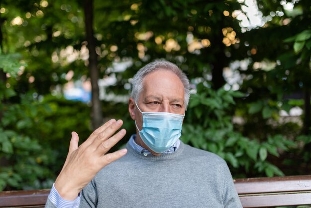 Mann, der Schwierigkeiten hat, mit seiner Maske zu atmen, Coronavirus-Prävention in heißem Klima Konzept