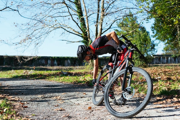 Mann, der sein Fahrrad in einem Park justiert