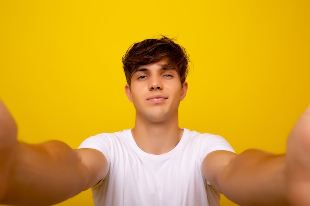 Mann, der Selfie-Foto über gelbem Hintergrund macht