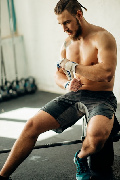 Mann, der sich auf das Training vorbereitet und ihre Hände mit Verbandband umwickelt