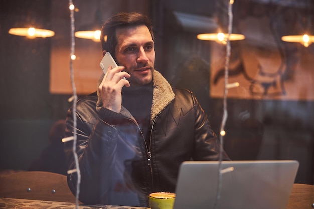 Mann, der sich mit Kaffee und Gadgets in der Bar entspannt