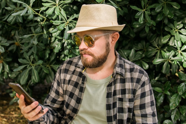 Mann, der soziale Netzwerke scrollt, glücklicher Tausendjähriger, der Sommerferien in Stadtjugend und Techno genießt