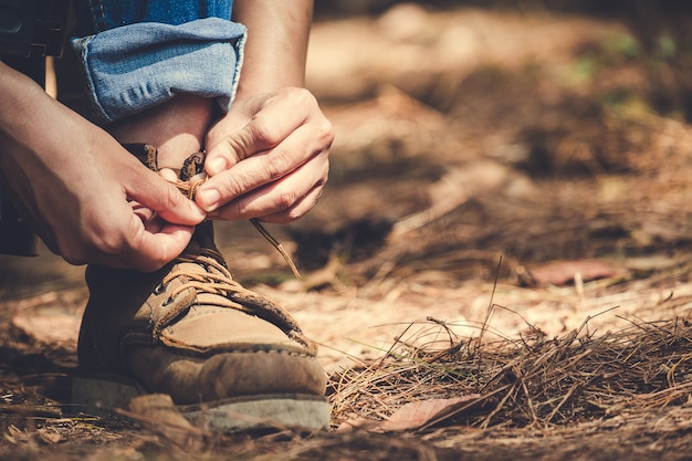 Mann, der Spitze für Trekking bindet