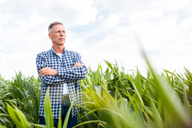 Mann, der stolz für die Kamera auf einem Feld aufwirft