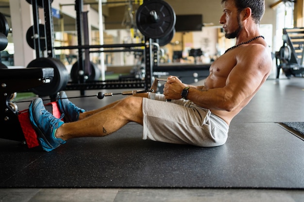 Mann, der Traktionsübungen auf einem Fitnessgerät macht