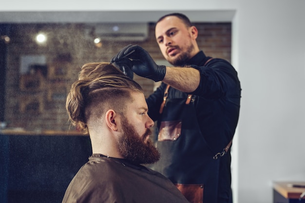 Mann, der trendigen Haarschnitt am Friseurladen erhält