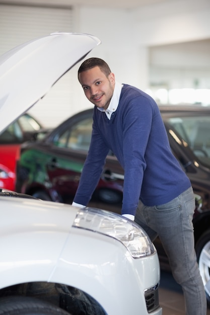 Mann, der über einem Auto sich lehnt