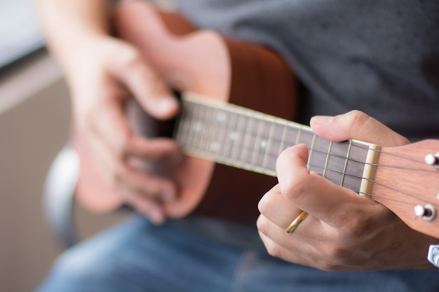 Mann, der Ukelele mit vorgewähltem Fokus spielt