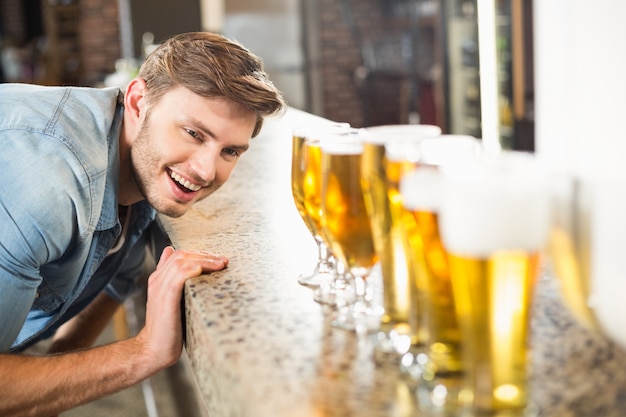 Mann, der unten gereihte Biere schaut