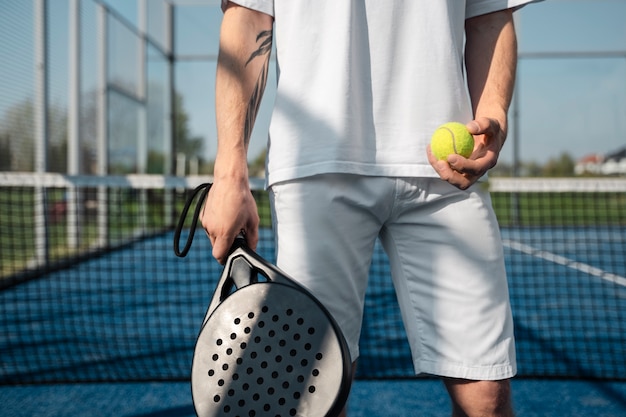 Mann, der Vorderansicht des Tennispaddels hält