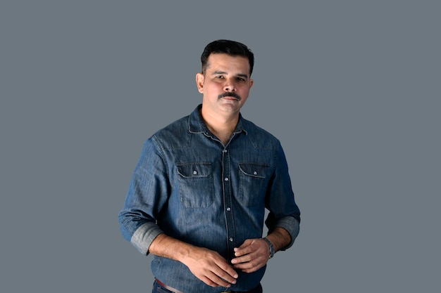 Mann, der vorne gegen graue Wand steht, indisches pakistanisches Modell
