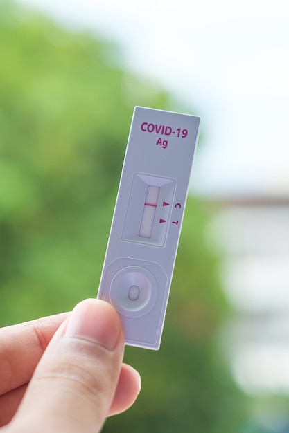 Mann, der während des COVID-19-Tests einen schnellen Antigen-Test mit negativem Ergebnis hält. Coronavirus Selbst-Nasen- oder Heimtest, Lockdown- und Home-Isolation-Konzept