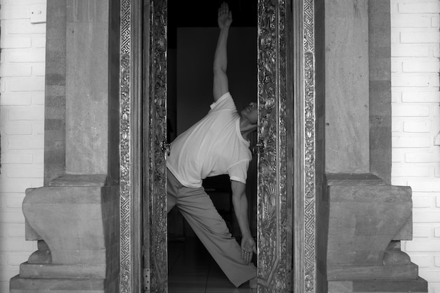 Mann, der Yoga macht, durch die Tür gesehen