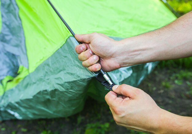 Mann, der Zelt installiert. Tourist im Freien. Camping im Wald.