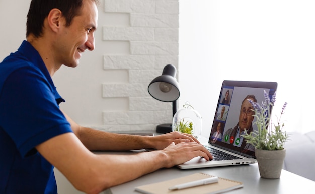 Mann, der zu Hause Video-Chat mit Arzt auf Laptop hat