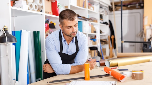 Mann-Designer und Druck-Operator mit Papierdruck bei der Druckherstellung