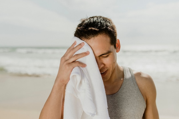 Mann entspannt sich nach dem Training am Strand