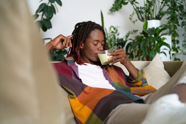 Mann entspannt sich zu Hause und genießt eine Tasse Matcha-Tee