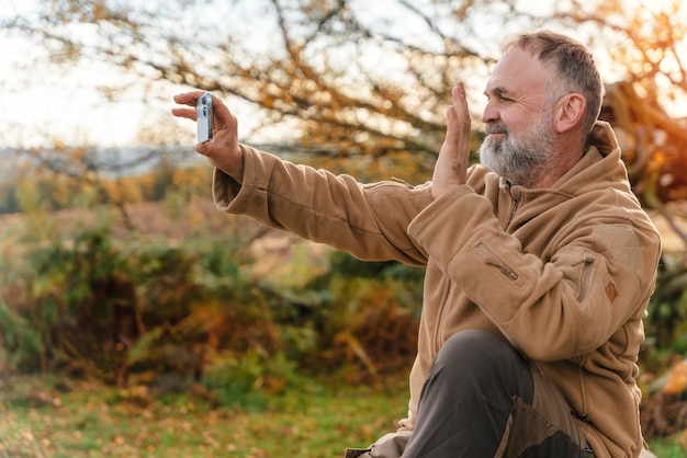 Mann erreicht Ziel, ruht sich aus und macht Fotos am Telefon im Peak District