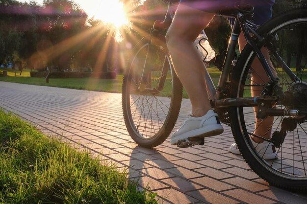Mann fährt an einem sonnigen Tag bei Sonnenuntergang draußen im Park Fahrrad, Nahaufnahme, aktiver Lebensstil