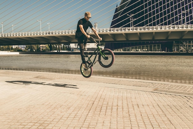 Mann fährt auf einem BMX-Rad auf einem Fußweg in der Stadt