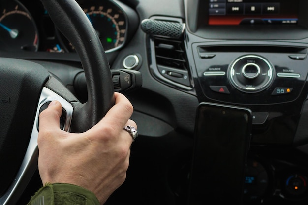 Mann fährt Auto. Autoinnenraum. Mannhand am Lenkrad. Auto-Dashboard. Reisekonzept.