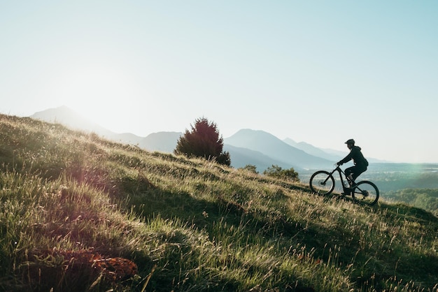 Mann fährt Fahrrad auf dem Feld gegen klaren Himmel