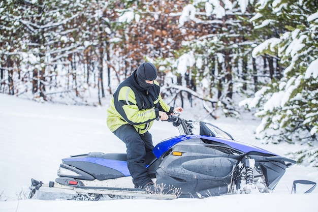 Mann fährt Schneemobil in den Bergen