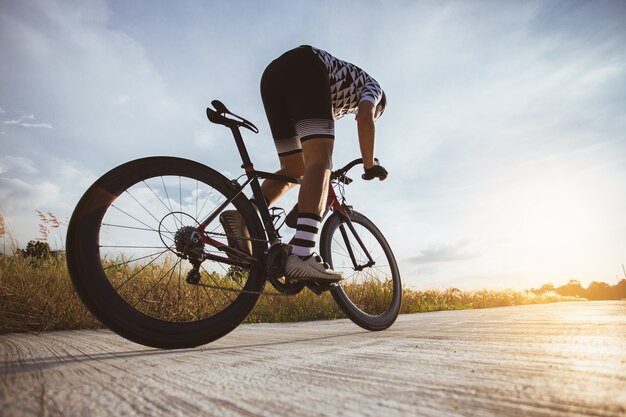 Mann Fahrrad fahren bei Sonnenuntergang Das Bild des Radfahrers in Bewegung auf dem Hintergrund am Abend