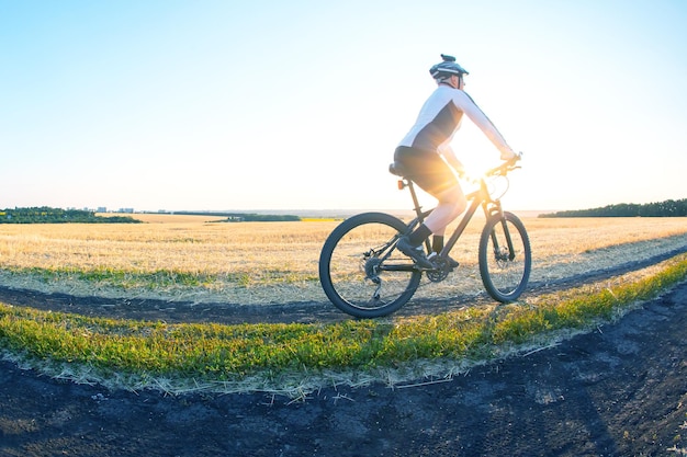 Mann Fahrradfahrer fährt Fahrrad auf einer Straße in der Natur Sport Fahrradfahren und Gesundheit Hobbys