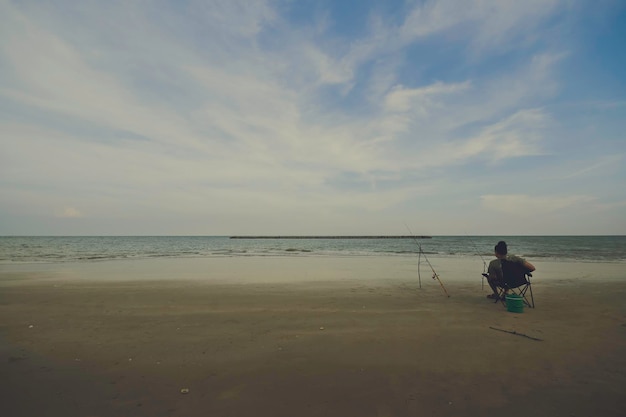 Mann fischt abends am Meer