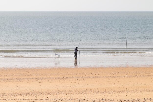 Mann fischt am Strand mit Rod Hobby-Konzept