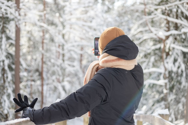 Mann fotografiert verschneiten Wald