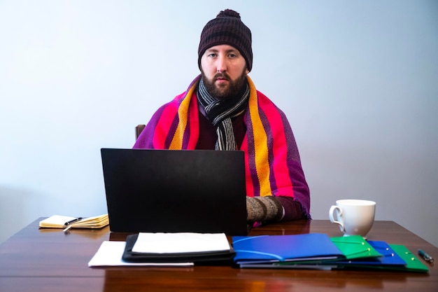mann friert während der arbeit im büro kalt zu hause kalt bei der arbeit energiekrise 2022 winter 2022