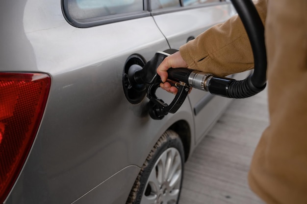 Mann füllt den Kraftstofftank des Autos mit Dieselkraftstoff an der Tankstelle aus der Nähe, da die Kraftstoffkosten steigen