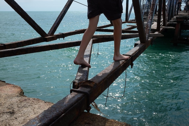 Mann geht und balanciert auf kaputter Brücke