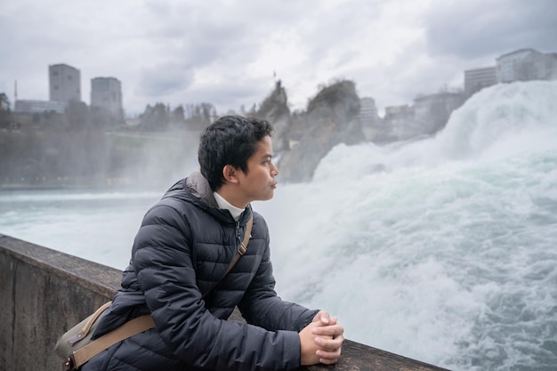 Mann genießt den Blick auf den Rheinfall während der Wintersaison in der Schweiz