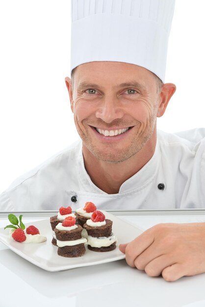 Foto mann gesicht und chef dessert im porträt und lächeln bäcker geschicklichkeit und kuchen präsentation isoliert auf weißem hintergrund glückliche person schokolade und obst zum valentinstag teller und gastfreundschaft im studio