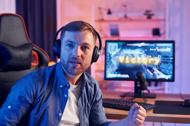 Mann gewinnt dieses Spiel Online-Streamer, der zu Hause FPS-Shooter spielt